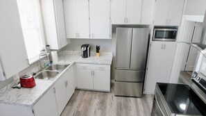 Modern kitchen with brand new stainless steel appliances.