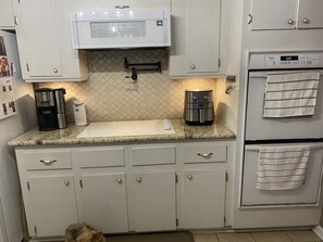 Smooth glass top stove, coffee maker, can opener, air fryer.  Double wall oven.