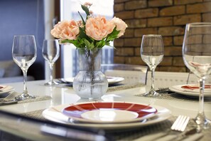 A close-up of a beautifully set dining table with elegant glassware and flowers as the centerpiece, creating a sophisticated dining atmosphere.