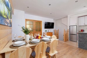 A dining table set with breakfast in a rustic wooden interior.
