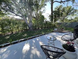 Patio with plenty of shade in the afternoon. The backyard is fenced. 