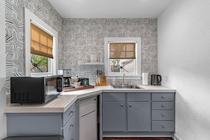 The guest house kitchenette with its chic, contemporary design comes equipped with a fridge, microwave and full coffee setup.