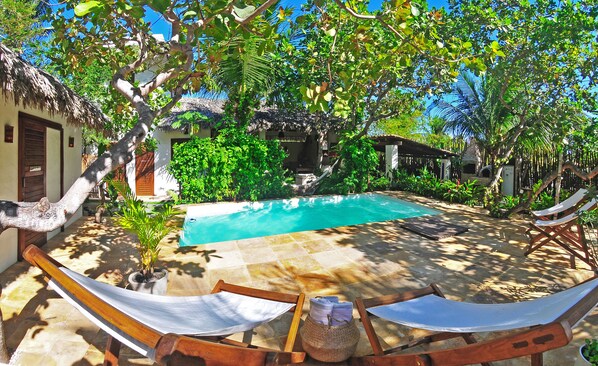 6x3m pool with large pool deck with 4 pool chairs and 2 fatboys set up garden.