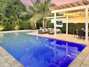 Large heated pool with shallow sunbathing area. 