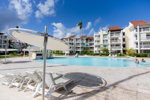 Swimming pool patio. Sun chair loungers. Umbrella. 