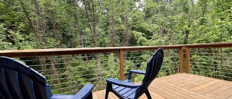 Large deck to sit back and enjoy the day looking out over the creek and trees. 