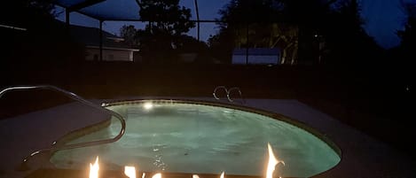 Outdoor fireplace poolside.