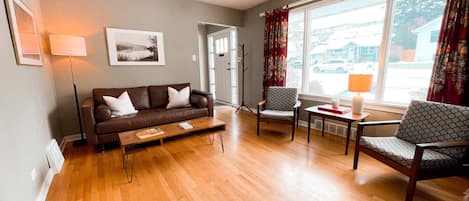 Living room with leather Article couch and mid-century teak side chairs