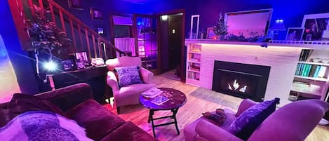 Lovely living room with gas fireplace. Multicolored hue lighting throughout