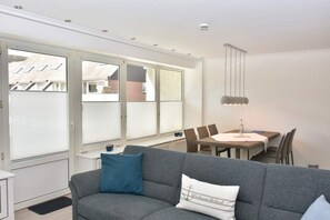 Wohnzimmer mit großem Esstisch und Zutritt zum Westbalkon