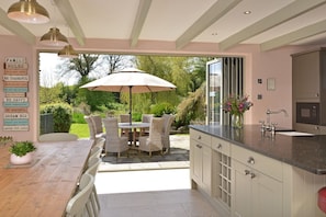 Kitchen bi-fold doors open onto terrace and gardens