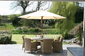 Kitchen terrace overlooking gardens and pond