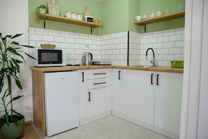 Kitchen with an induction stove, electric kettle, and a microwave