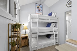 A dynamic loft space great for families and children features a triple bunk bed all with twin mattresses.