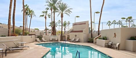 Communal Area: Sparkling blue pool with sun loungers and access to the sports court.