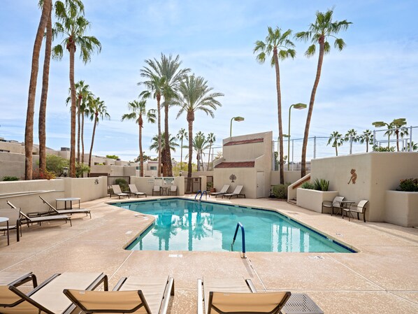 Communal Area: Sparkling blue pool with sun loungers and access to the sports court.