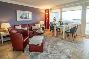 Wohnzimmer mit Sofa, Sessel und Essplatz
