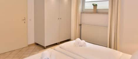 3. Schlafzimmer im UG mit Doppelbett, Kleiderschrank und Fenster