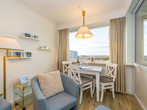 Wohnzimmer mit Sessel und Essplatz am Fenster