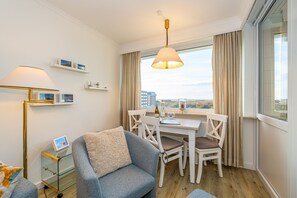 Wohnzimmer mit Sessel und Essplatz am Fenster