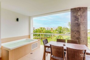 A spa tub and dining table and lush views