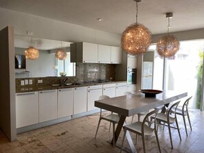 Modern kitchen and dining area with stylish lighting, perfect for family meals.