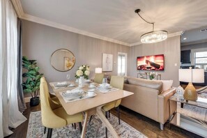 An open living and dining area with a sophisticated, modern design, offering stylish seating for four—perfect for both relaxation and entertaining.