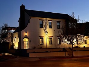 The warm gas lamp welcomes guests arriving for a quiet evening