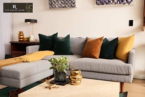 Our living room, with a brass-adorned table, boasts beautiful, relaxing chairs.