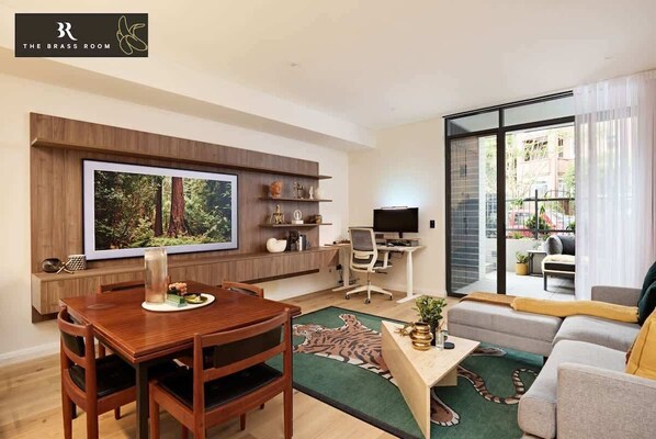 Our living room, with a brass-adorned table, boasts beautiful, relaxing chairs and a work-from-home setup. It's a comfortable and stylish space for both relaxation and productivity.