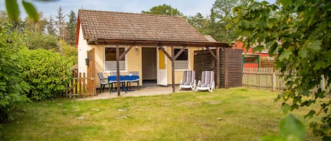 Außenansicht. Gartenmöbel, überdachte Südterrasse, eingezäuntes Grundstück.