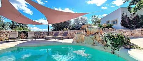 Wonderful rounded pool with a partially shaded area to relax.