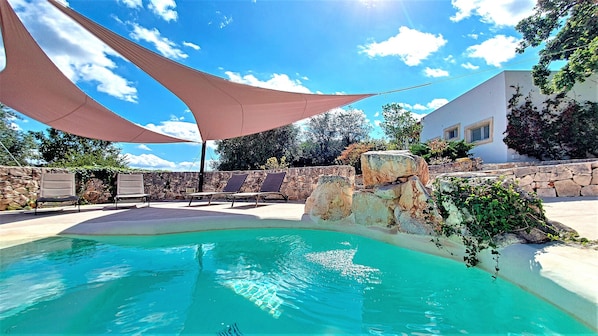 Wonderful rounded pool with a partially shaded area to relax.