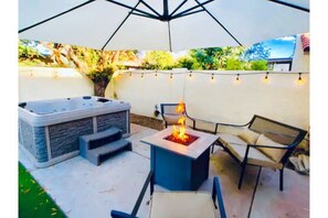 A private HOT TUB for your use, fire pit, outdoor dining area, and putting green