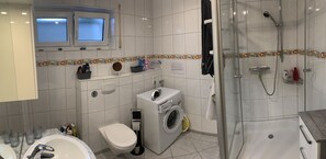 Badezimmer mit Dusche und Waschmaschine