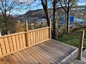 Deck off back sun room The yard is filled with foliage in the summer.