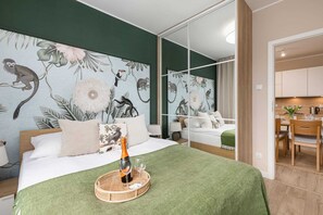 A serene bedroom featuring a forest-themed wall mural, a green bedspread, and stylish decor.
