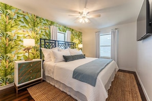 The Jungle Room has a king sized Nest Bedding pillow top mattress, luxe linens, 55" smart TV and the cutest flamingo lamps ever!