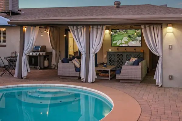 Outdoor living space with 65" TV, BBQ, Patio seating and pool bath.