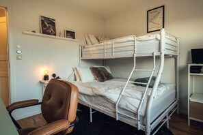 Sovrum på nedre plan med plats för tre personer. Skrivbord finnes även.