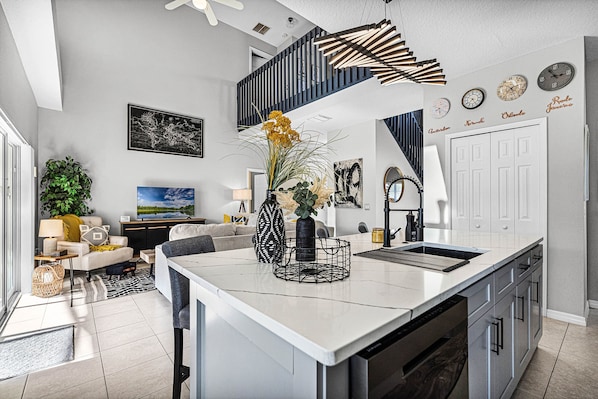 Kitchen island with comfortable bar seating overlooking main living area & pool