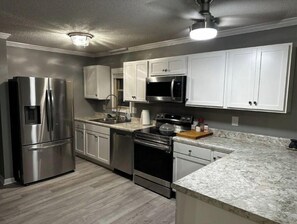Accessible kitchen stocked with cookware, dinnerware, and utensils.
