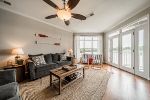 Living rom with nautical decor, deck access & TV.