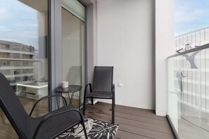 Private balcony with a seating area, offering a relaxing spot with views of the surroundings.