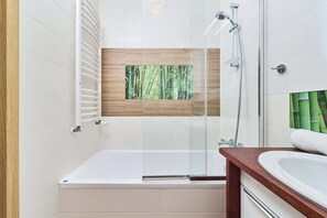 A bright bathroom with a bathtub.