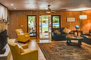 Cozy family sitting room with a large TV , fireplace and view of the pool area. (1)