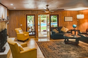 Cozy family sitting room with a large TV , fireplace and view of the pool area.