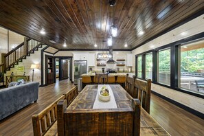Rustic dining table with views from large windows of the surrounding trees.