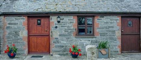 Part of the front of the cottage, showing living room door and bedroom door.