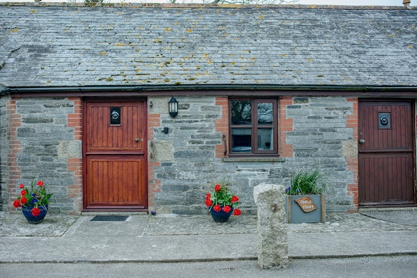 Part of the front of the cottage, showing living room door and bedroom door.